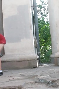 Light-haired In Red Dress Pisses On The Grass Outside